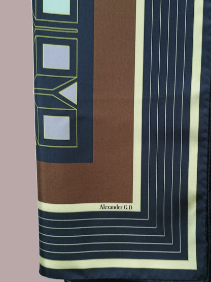 Silkscarf Granada stripes drapes softly over a model's shoulder, revealing the high level of craftsmanship in the silk print machine/hand roll hemming