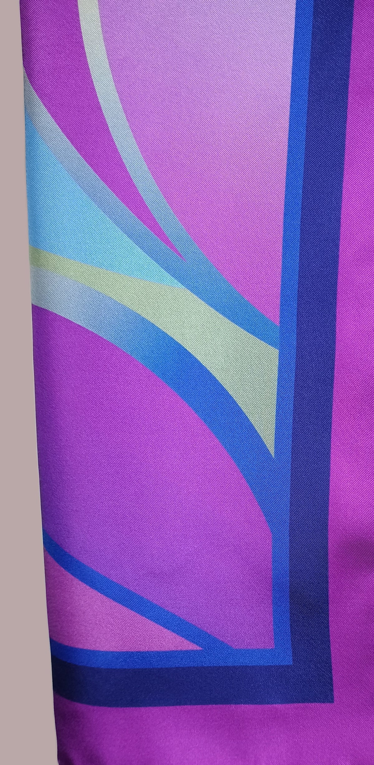 Colorful abstract design on a fabric swatch with pink, purple, blue, and green colors.