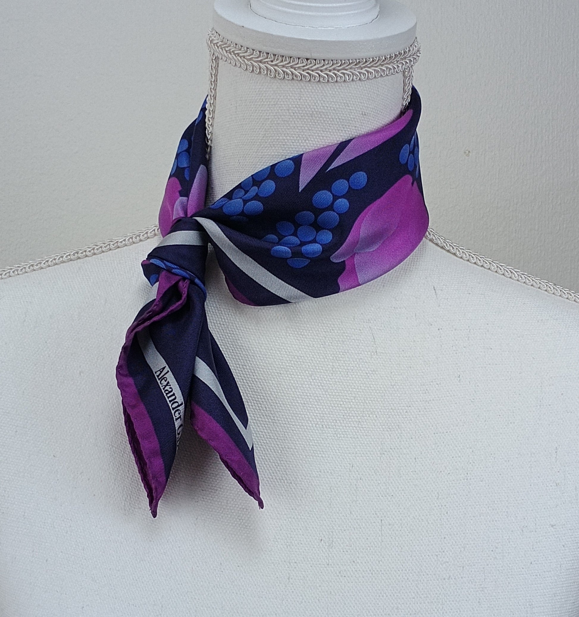 A tie with a Navy dark pink floral pattern on a mannequin bust.